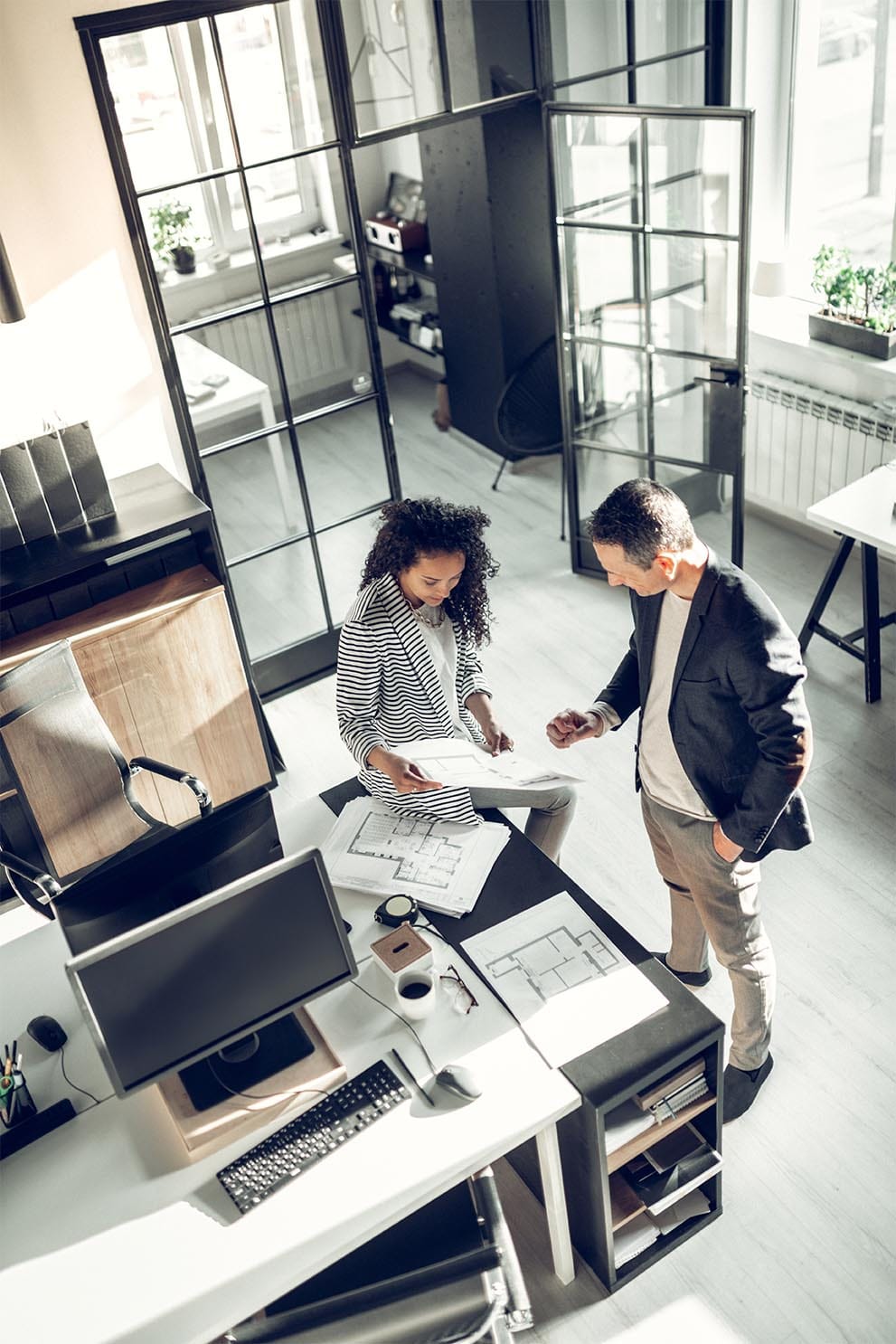 Designers reviewing floor plans together in a studio workspace