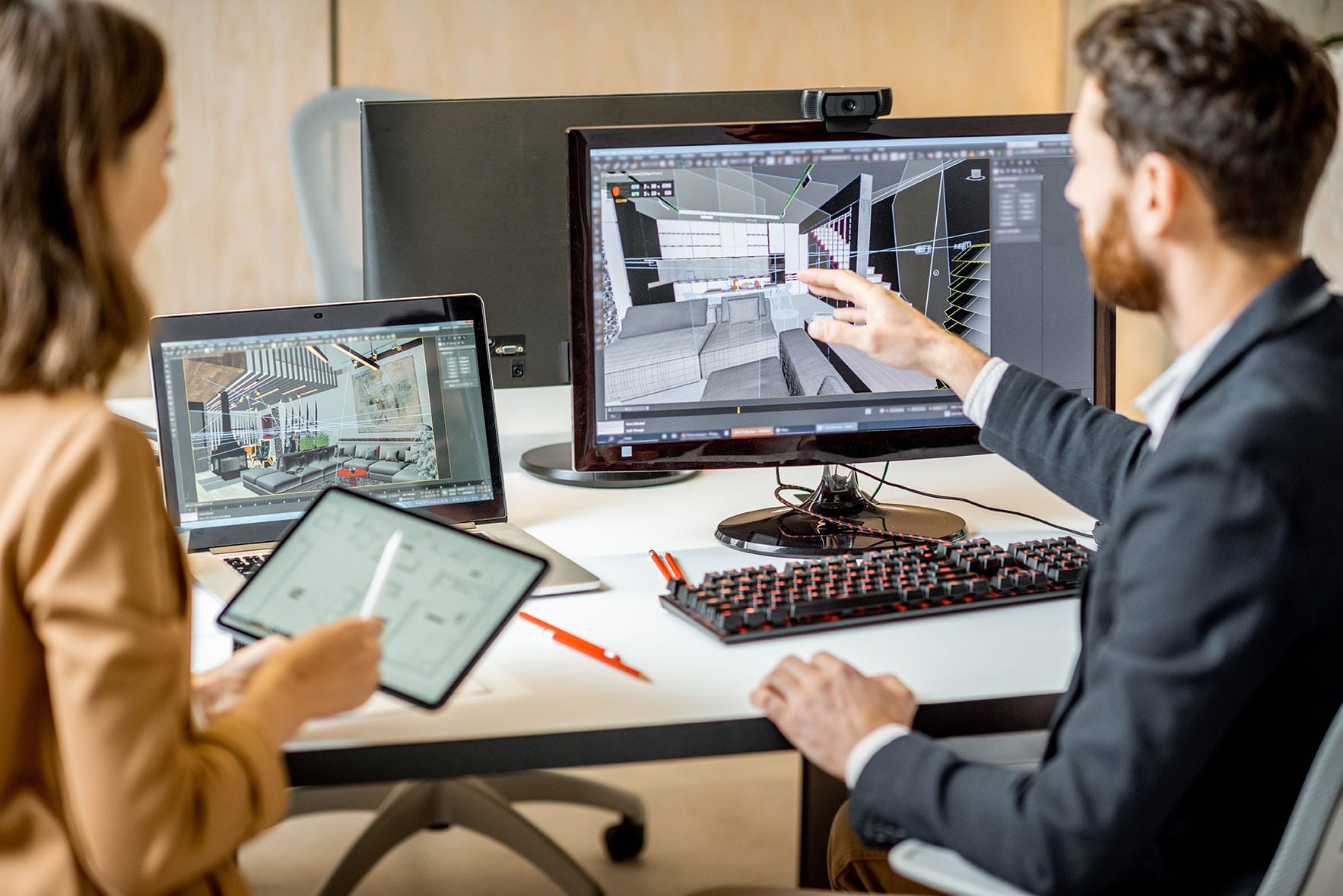 Two designers reviewing a 3D interior visualisation at a workstation
